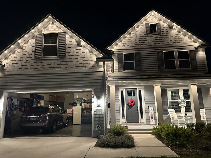 Gabled home with warm white lights tracing both rooflines
